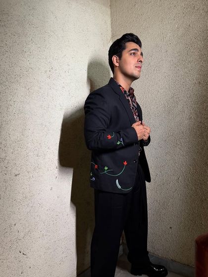 A full-length shot of Gagan Arora's promotional look, showing the complete outfit with relaxed-fit trousers and chunky shoes.