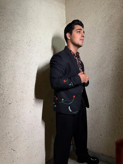 A full-length shot of Gagan Arora's promotional look, showing the complete outfit with relaxed-fit trousers and chunky shoes.