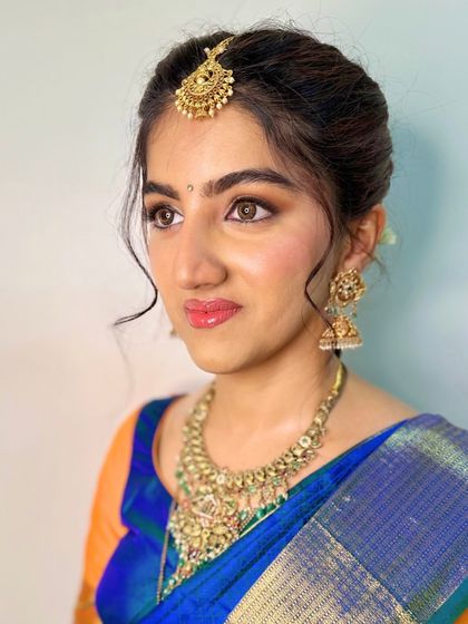 This portrait captures a soft and dreamy expression. The makeup is focused on creating a flawless canvas, with subtly enhanced eyes and a natural lip color.