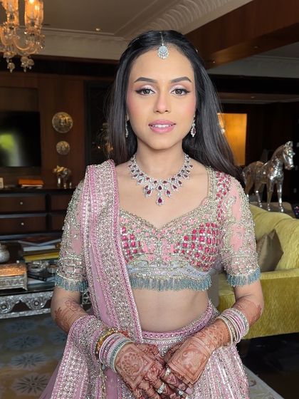 A happy bride showing off her complete Mehendi look, with her sparkling hairstyle adding the perfect touch of glam.