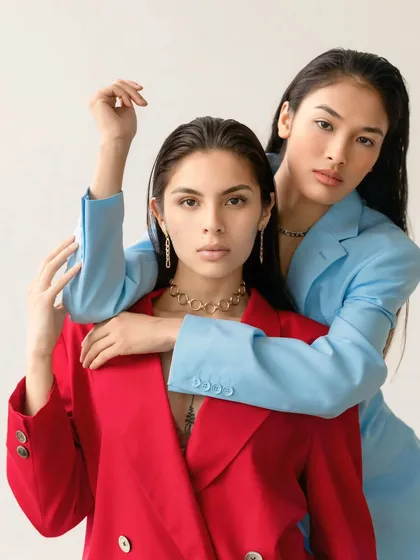Two models pose together in a studio, one in a bold red power suit and the other in a cool blue one. This conceptual shoot showcases my ability to create striking, high-contrast images for brands and editorial features.