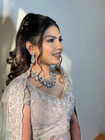A happy, confident smile. Her sangeet makeup was designed to be bold yet elegant, with a focus on a flawless, glowing complexion.