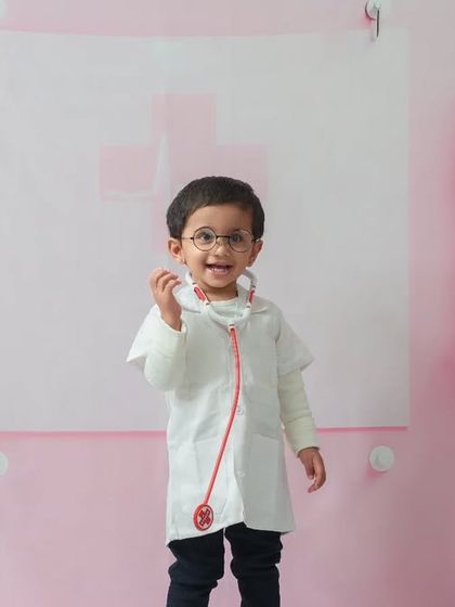 Checking for a healthy heartbeat. Dressed in a little white coat with a stethoscope, this toddler is fully in character for his fun and imaginative photoshoot.