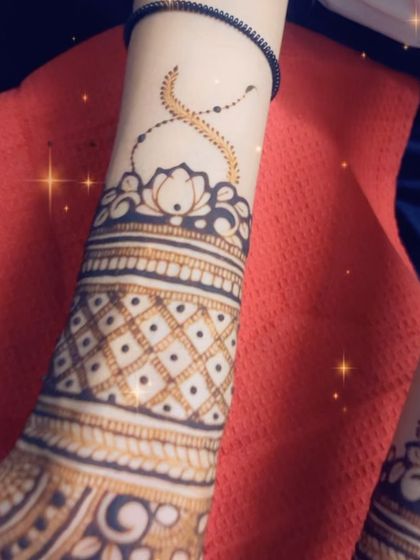 A beautiful Indian design with a lotus motif at the wrist and a delicate vine extending upwards. The checkerboard pattern on the arm adds a classic touch.