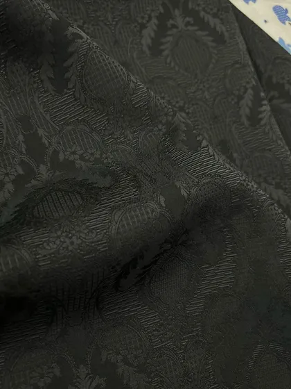 A black-on-black jacquard fabric, featuring a subtle pattern for an elegant and understated evening jacket.