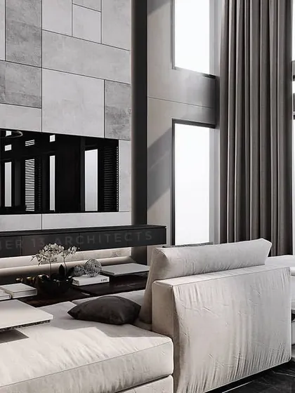 In this residence, we created a double-height living space with a monolithic grey marble feature wall for the television and fireplace. The monochromatic palette is softened by a plush white sectional sofa and abundant natural light from tall windows.