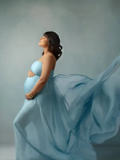 Feeling the breeze. This pose with the flowing blue fabric captures a sense of freedom and release.