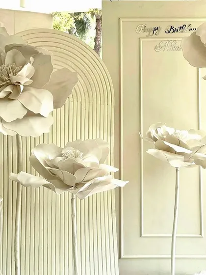 A minimalist and modern birthday backdrop with giant white paper flowers.