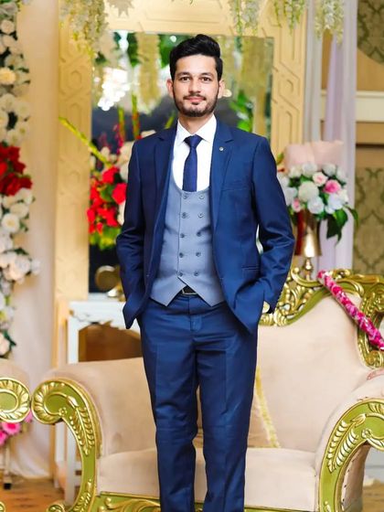 A full-length view of a groom in a three-piece suit. The fit is perfect, and his stance exudes confidence.