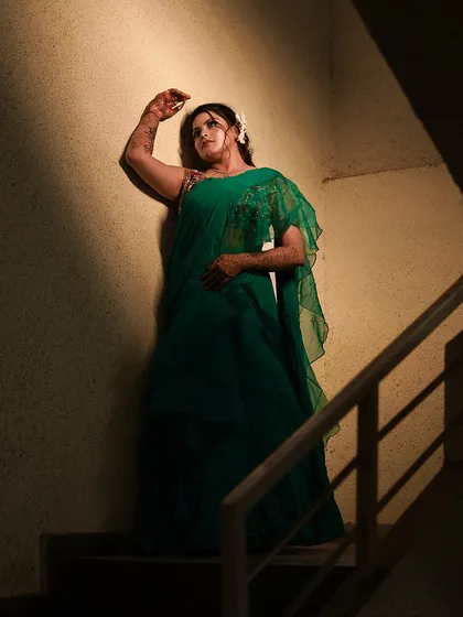 Shadow and light play a huge role in creating dramatic portraits. Here, the light falls across the bride in a way that feels cinematic and artistic, highlighting the flow of her green saree while shrouding the surroundings in mystery.