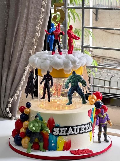 This towering Avengers cake was an epic project, featuring multiple tiers, a city skyline with lights, and a floating Batman topper. It’s a true blockbuster cake for a super celebration.