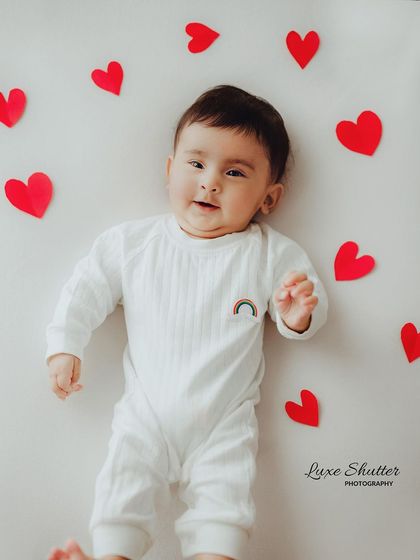 Surrounded by love. This simple and sweet setup with red hearts is a beautiful way to capture a baby's portrait at any milestone.