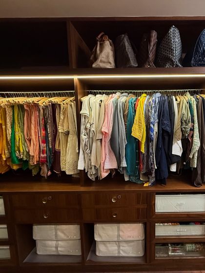 A wide view of a closet showing how we balance hanging space with open shelving for bags and bins, creating a varied and functional storage system.