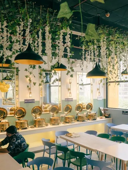 This is our clean and modern dining space at Spectrum Mall, Sector 75. I've designed it to be a comfortable and welcoming place for you to relax and enjoy your meal, with plenty of natural light and fresh decor.