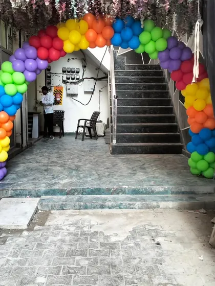 A rainbow balloon arch at the entrance, hinting at the colorful Cocomelon party waiting inside.