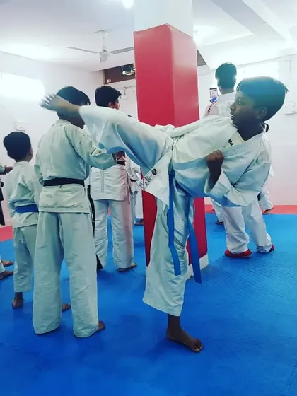 A young student practices a high kick during the seminar, showing great potential and focus.