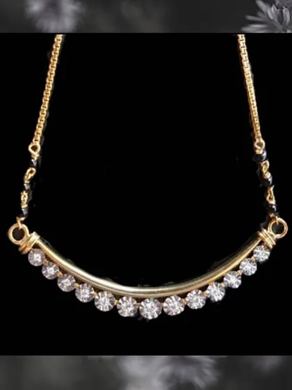 This design features a curved gold bar set with a line of round diamonds. It is a chic and minimalist take on the traditional mangalsutra, perfect for office or casual wear.