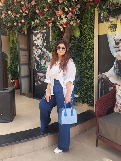 Posing against a vibrant backdrop, this outfit proves that even classic combinations can be exciting.