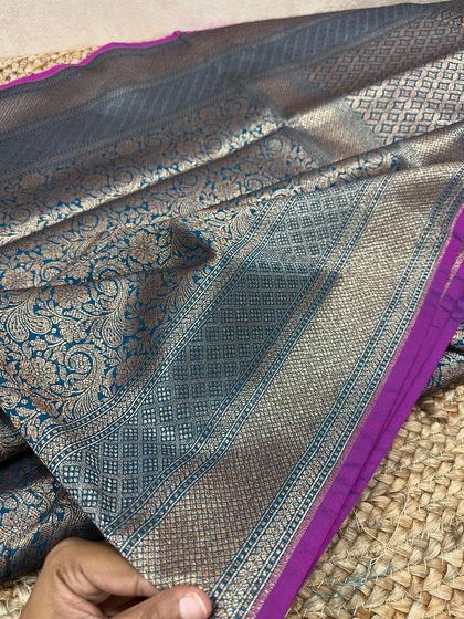 The complete look of this teal and magenta Banarasi silk saree. The pallu is a masterpiece of floral and diamond-patterned jaal weaving.