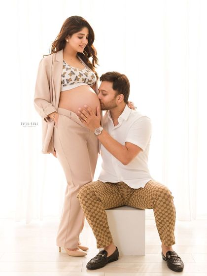 A kiss for the baby on the way. This classic pose is a beautiful way to show the father's love and excitement for his unborn child.