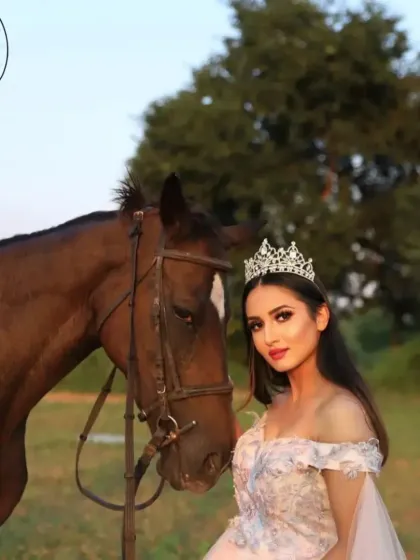 A fairytale-inspired photoshoot with a model in a beautiful gown and tiara. The natural, green background and the noble horse complete the enchanting scene.