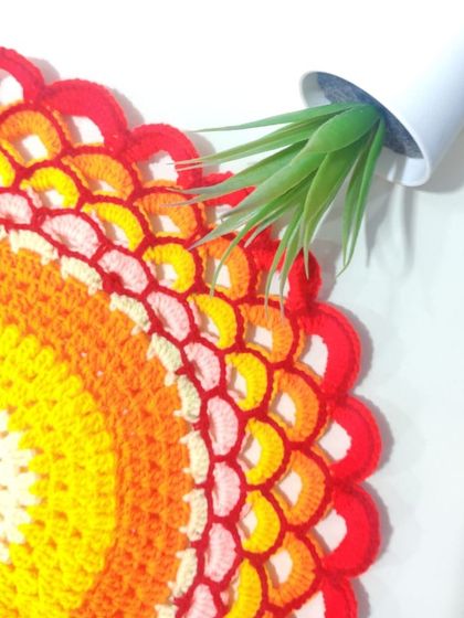 A close-up of the sunset doily, showing the intricate stitch work that creates the layered, scalloped effect.