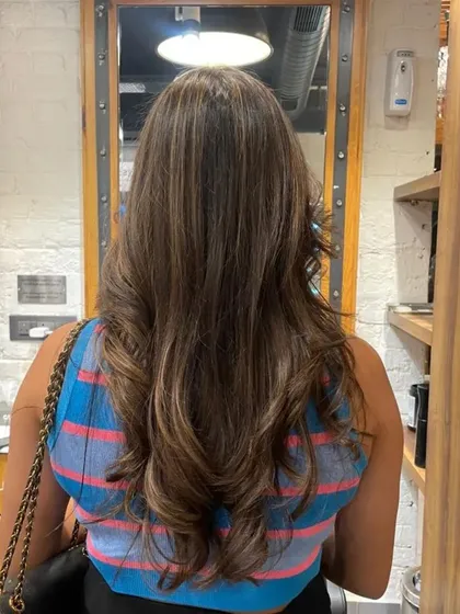 A back view of the finished without-bleach balayage, styled with soft waves to showcase the subtle color.