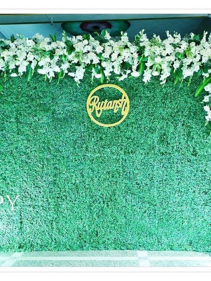 A full view of the greenery backdrop featuring the golden name cutout "Rutansh". The simple design makes the name the star of the show.