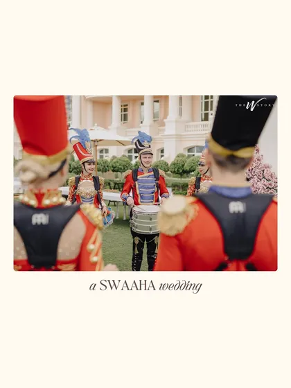 A full view of the marching band in their striking red and blue uniforms, adding a touch of regal, old-world charm to the procession.