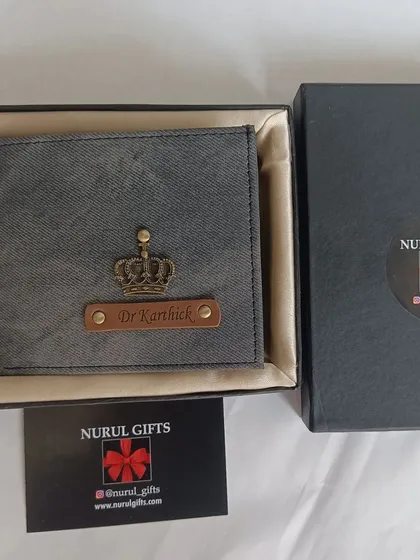 The personalized grey denim wallet with a crown charm, neatly placed in its gift box.