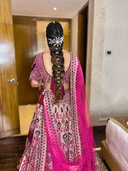 A sleek braided hairstyle for my bride Surbhi's regal look, adorned with a stunning hair accessory.