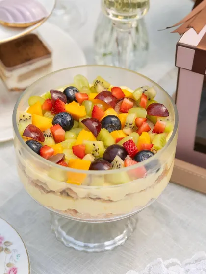 The full view of my summer Napoleon, a beautiful glass bowl layered with cream and pastry, and topped with a colorful medley of fresh seasonal fruits.