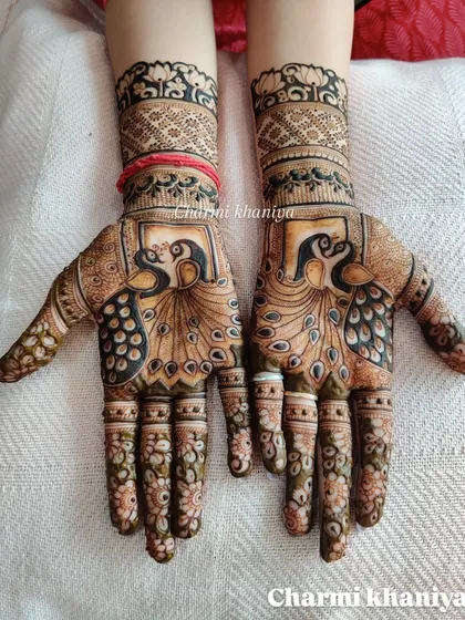 A bold and beautiful peacock design. The use of negative space makes the peacock's form stand out, while the fingers are decorated with delicate floral patterns.