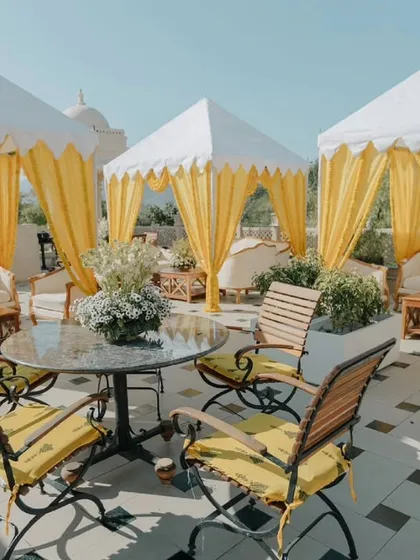 An elegant rooftop seating area with yellow-draped cabanas for a Haldi ceremony. We create comfortable and stylish spaces for guests to relax and enjoy the festivities.