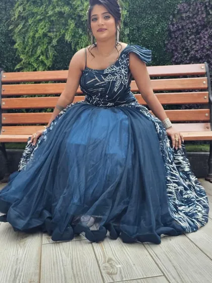 The client seated in the navy blue gown, showing the dramatic and voluminous skirt.