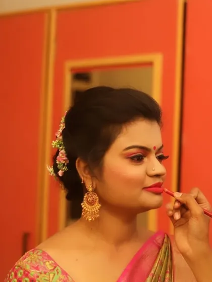 The final touch. In this photo, I am carefully applying lipstick for a client's reception look. A precise lip line is essential for a polished and long-lasting finish.