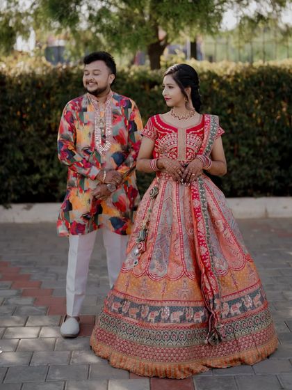 A colorful and happy portrait of the couple in their vibrant Sangeet outfits.
