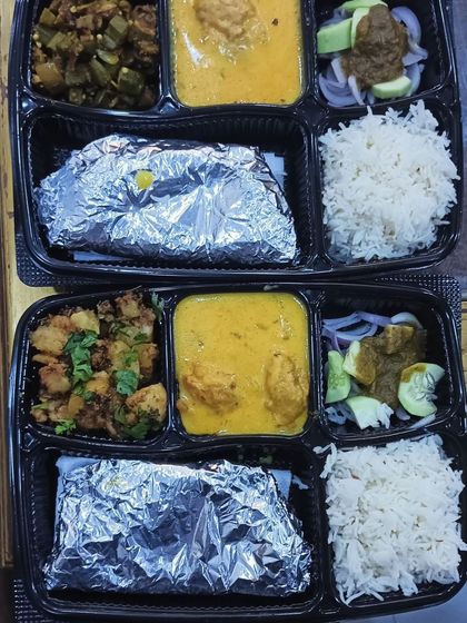 A variety of thalis ready for dispatch. You can see options like kadi with bhindi and kadi with jeera aloo, all packed and ready to go.