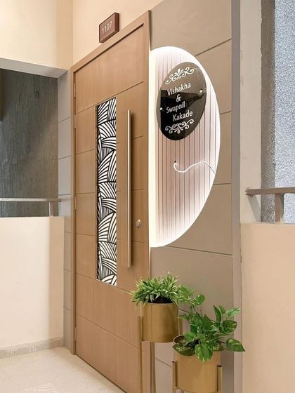 Another angle of the main door, with planters added to bring a touch of nature to the entrance. The combination of wood, light, and greenery creates a welcoming feel.