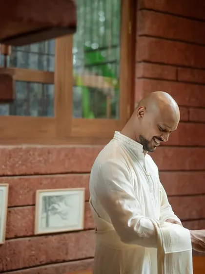 A candid moment of the groom getting ready. This shot captures the quiet, personal moments before the ceremony, focusing on the details and the calm energy.