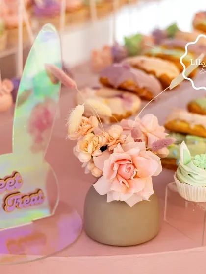 The "Sweet Treats" station, marked with an iridescent bunny-eared sign and adorned with fresh flowers.
