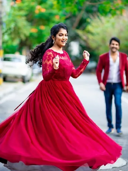 A moment of pure joy and dance. This deep red gown with delicate lace sleeves is perfect for capturing candid, happy moments during a pre-wedding or post-wedding shoot.