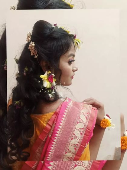 This side profile captures the harmony between the makeup, the fresh flower earrings, and the soft hairstyle. Our training emphasizes creating a cohesive and balanced look for the client.