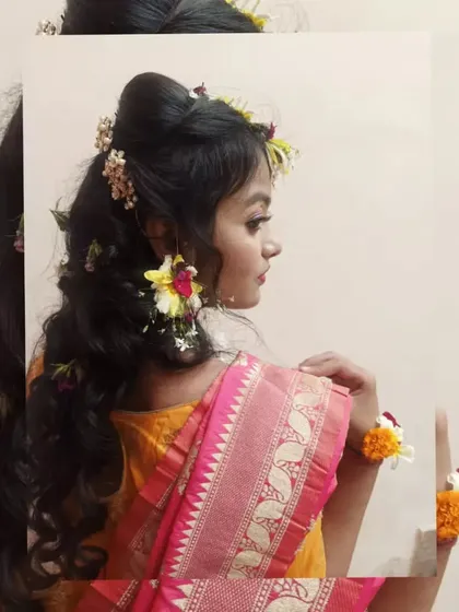 This side profile captures the harmony between the makeup, the fresh flower earrings, and the soft hairstyle. Our training emphasizes creating a cohesive and balanced look for the client.