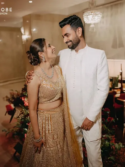This couple is the definition of elegance. Her golden lehenga and his classic white bandhgala are a perfect match for a sophisticated reception look.