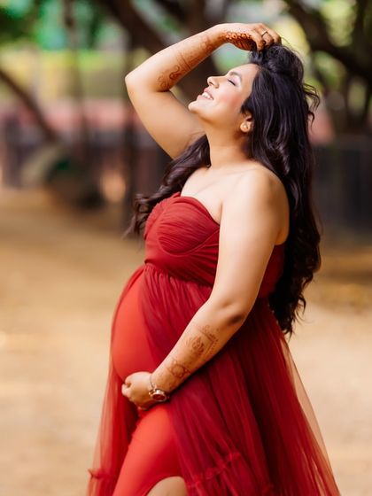A radiant mom-to-be enjoys the sunshine during her outdoor maternity shoot. Her joyful expression and the warm light create a beautiful, glowing portrait.