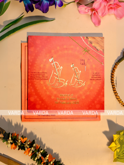 A unique thread ceremony invitation with a vibrant orange textured background and gold foil motifs of traditional musical instruments. This design offers a culturally rich and artistic way to announce a sacred Upanayanam or Bratopanayan.