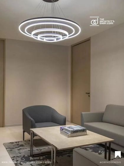 The waiting area in the Adani Realty office is designed with a minimalist aesthetic, featuring clean lines and modern circular lighting. The space is intended to be calm and welcoming, setting a professional tone for visitors.