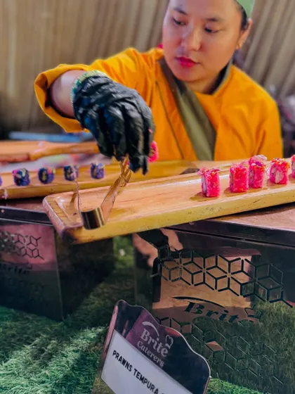 Artistry in every roll. My chef is seen here carefully plating Prawns Tempura sushi, showcasing the precision and fresh ingredients that define my Pan-Asian cuisine offerings.