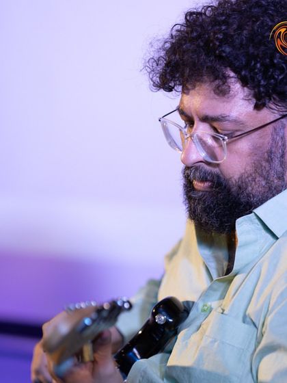 A close-up of me, lost in the music while playing guitar at one of our events. Sharing my passion with the students is what it's all about.